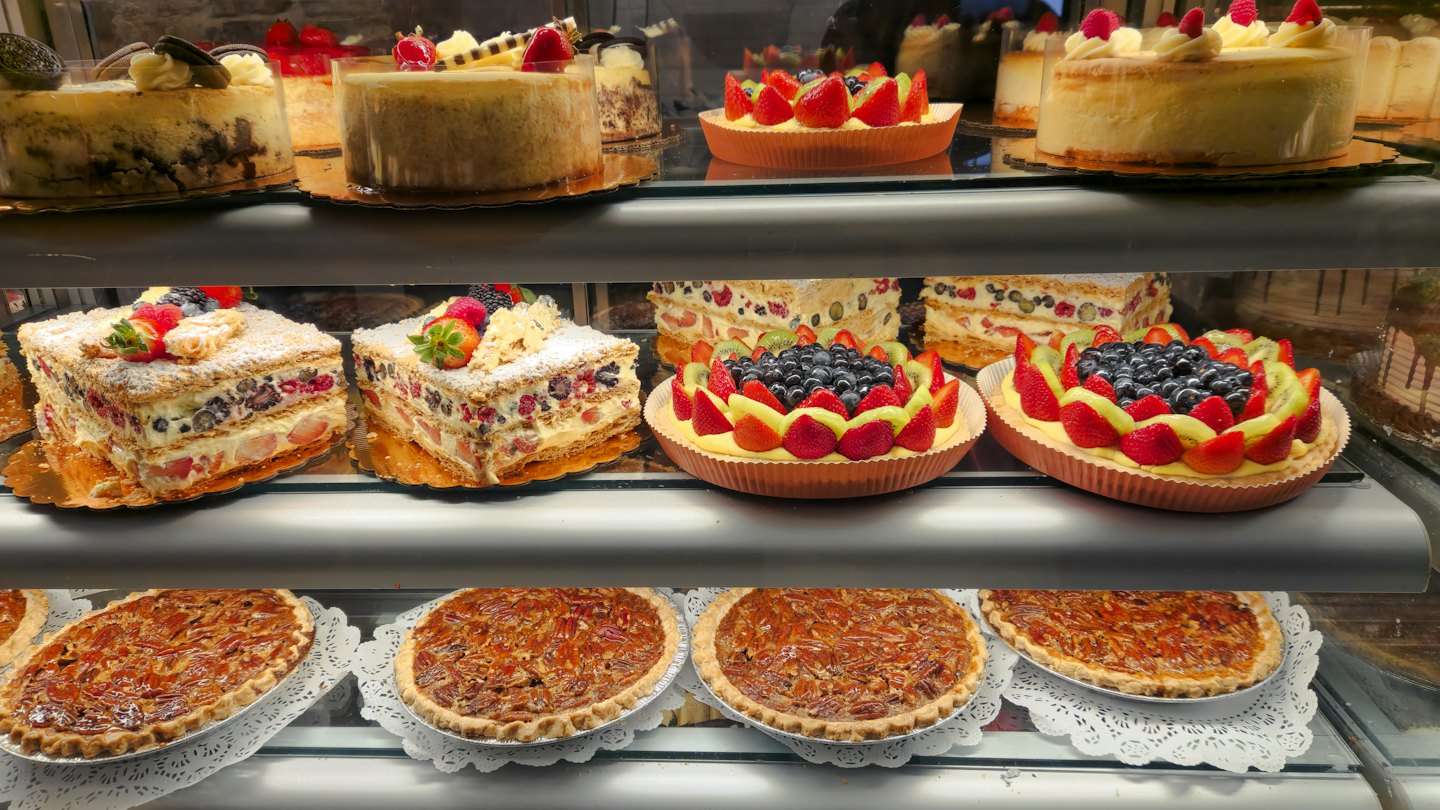 Assorted desserts displayed inside a glass bakery case.